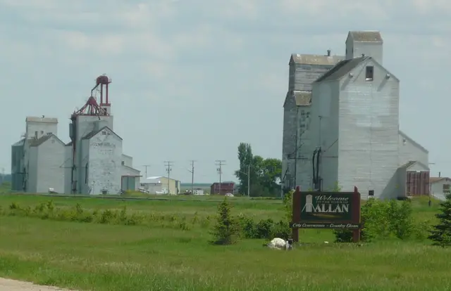Grain elevators and welcome sign at Allan